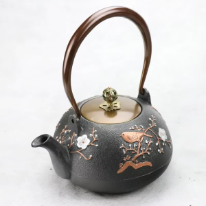 Teekanne aus Gusseisen mit Blumenmotiv und Vogel