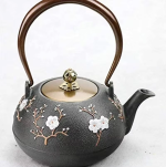 Teekanne aus Gusseisen mit Blumenmotiv und Vogel
