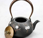 Teekanne aus Gusseisen mit Blumenmotiv und Vogel