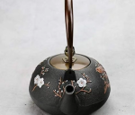 Teekanne aus Gusseisen mit Blumenmotiv und Vogel