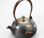 Teekanne aus Gusseisen mit Blumenmotiv und Vogel