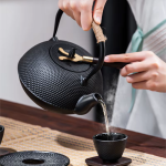 Teekanne aus Gusseisen, Teetasse und Untersetzer