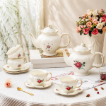 Teekanne oder Porzellantasse mit Untertasse im Blumenmotiv