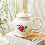 Teekanne oder Porzellantasse mit Untertasse im Blumenmotiv