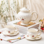 Teekanne oder Porzellantasse mit Untertasse im Blumenmotiv