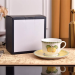 Teeservice mit Früchtemuster aus Knochenporzellan — Tasse mit Untertasse und gelb-orangen Früchten